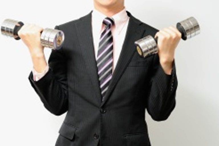 man in a business suit holding weights