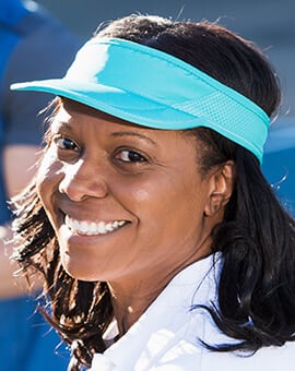 black woman wearing visor with tennis apparel