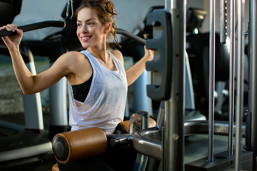 smiling woman on a strength training machine