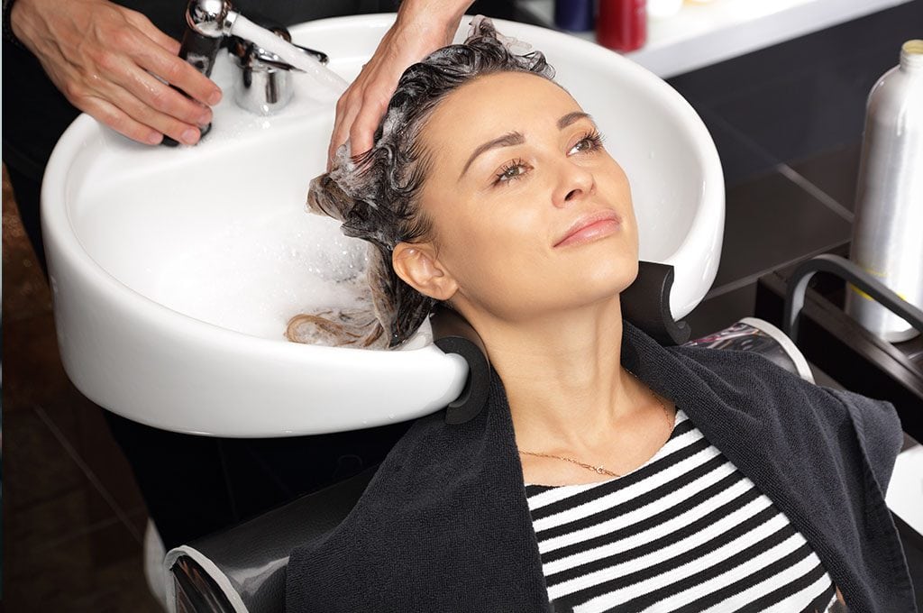 woman getting her hair washed in a salon sink