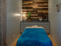 serene massage room with bamboo wall and blue velvet massage table