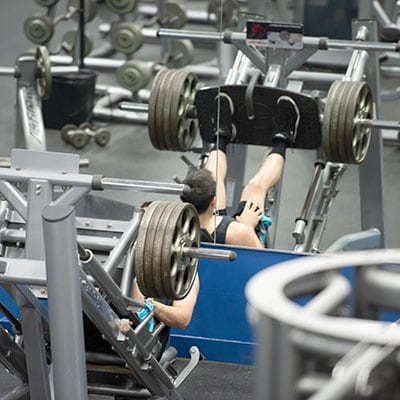 man in gym doing leg press on weight training machine